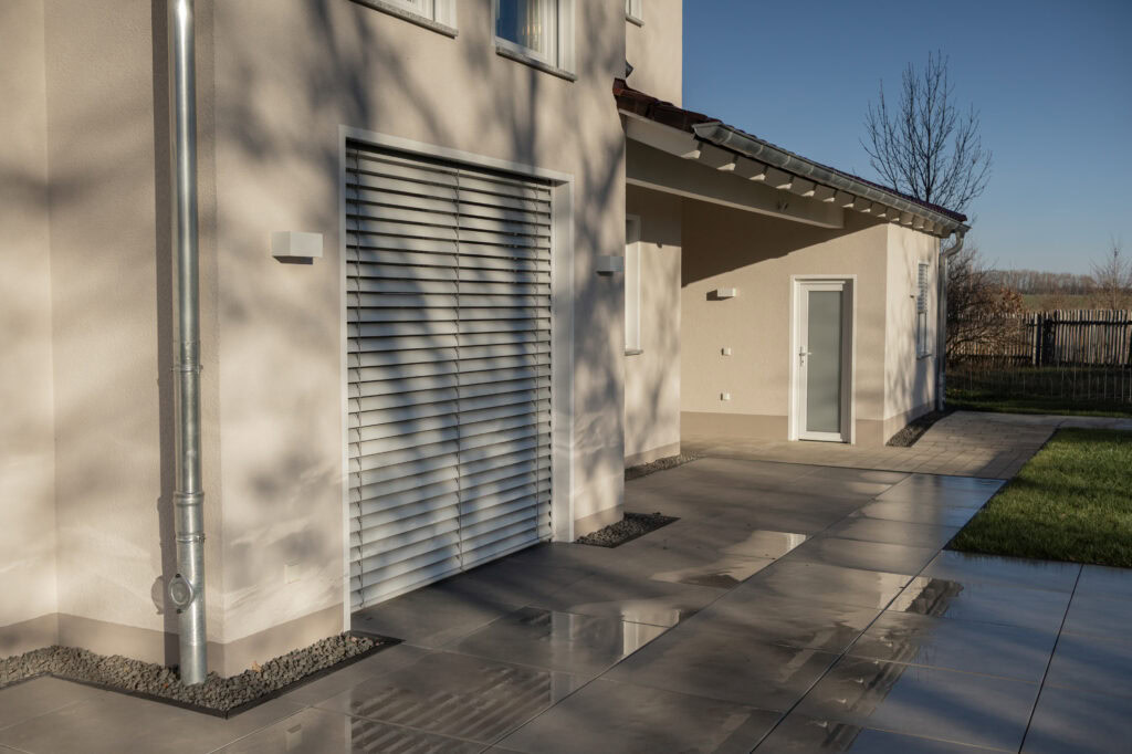 Hausfassade mit elektrischem Außenjalousien und Schattenspiel im Winter