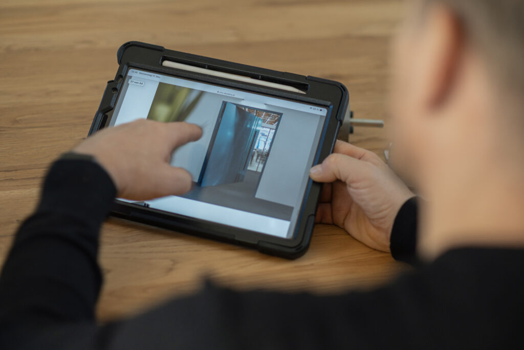Eine Person zeigt eine Innentür auf einem Tablet