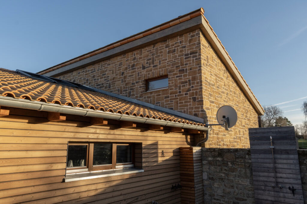 Hausansicht mit rustikal südländisches Flair und Fenstern mit Holzrahmen