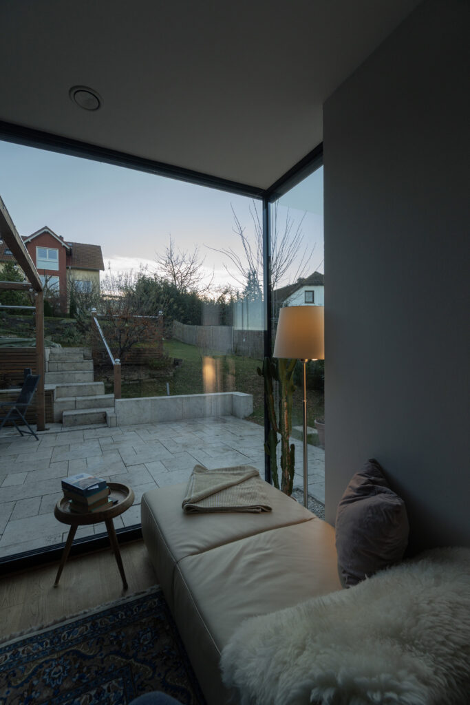 Abendstimmung in einem Wohnzimmer mit Blick in den Garten, Raumhohe Fensterfront